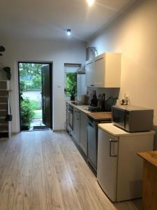 a kitchen with white cabinets and a wooden floor at Apartament Cozy Studio in Żagań