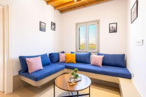 a blue couch in a living room with a table at Assyr A - Santorini Cozy Cycladic Retreat in Akrotiri