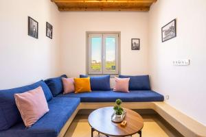 a blue couch in a living room with a table at Assyr A - Santorini Cozy Cycladic Retreat in Akrotiri