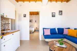 a living room with a blue couch and a table at Assyr A - Santorini Cozy Cycladic Retreat in Akrotiri