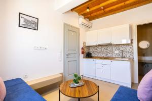 a living room with a blue couch and a table at Assyr A - Santorini Cozy Cycladic Retreat in Akrotiri
