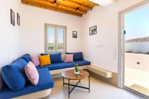 a living room with a blue couch and a table at Assyr A - Santorini Cozy Cycladic Retreat in Akrotiri +23 photos