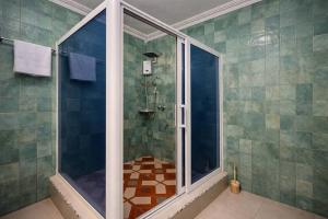 a shower with a glass door in a bathroom at Airport Side Hotel in Accra