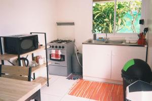 a small kitchen with a stove and a sink at Vahinui lodge in Bora Bora