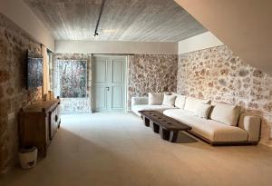 ein Wohnzimmer mit Sofa und Tisch in der Unterkunft Villa Anthousa luxury villas and suites in Anthoúsa