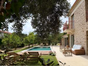 ein Garten mit Swimmingpool und ein Haus in der Unterkunft Villa Anthousa luxury villas and suites in Anthoúsa