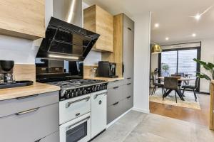 a kitchen with a stove and a dining room at Villa Boréal with spa in the heart of St Gilles in Saint-Gilles-Croix-de-Vie