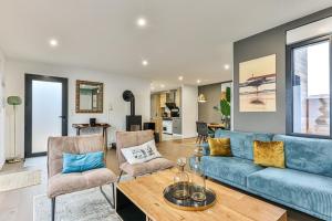 a living room with a blue couch and chairs at Villa Boréal with spa in the heart of St Gilles in Saint-Gilles-Croix-de-Vie