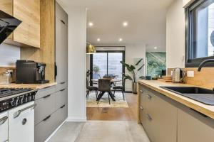 a kitchen with white cabinets and a dining room with a table at Villa Boréal with spa in the heart of St Gilles in Saint-Gilles-Croix-de-Vie