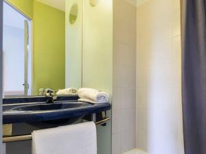 a bathroom with a sink and a mirror at ibis budget Châtellerault Nord in Châtellerault +48 photos