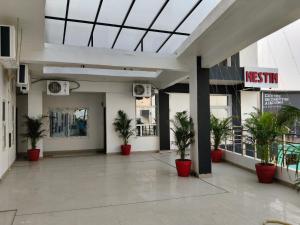 an empty lobby with potted plants in a building at NestIN hotels in Lucknow