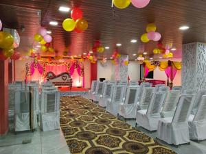 a row of white chairs in a room with balloons at NestIN hotels in Lucknow