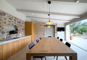 ein Esszimmer mit einem Holztisch und Stühlen in der Unterkunft Villa Anthousa luxury villas and suites in Anthoúsa