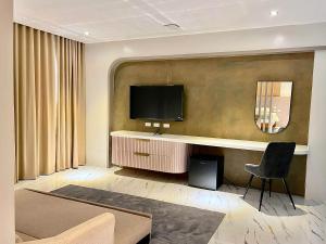a living room with a television on a wall at Achilles Hotel in Maitim