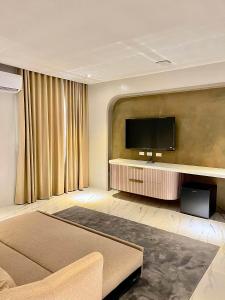 a living room with a flat screen tv on a wall at Achilles Hotel in Maitim