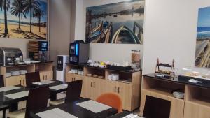 a dining room with tables and chairs and a tv at BLUESEA Faro Cullera in Cullera