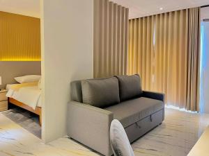 a bedroom with a couch in front of a bed at Achilles Hotel in Maitim