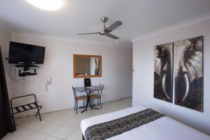 a bedroom with a bed and a flat screen tv at David Motor Inn in Rockhampton