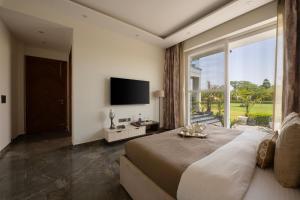 a bedroom with a large bed and a large window at Saffronstays Olive Farms in Mandkaula