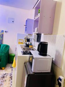 a kitchen with a microwave on top of a refrigerator at The Crown Stay in Machakos +3 photos