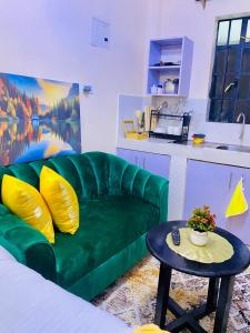 a living room with a green couch and a table at The Crown Stay in Machakos