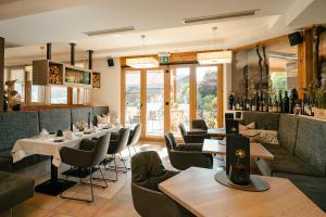 a restaurant with tables and chairs and a bar at Arlbergerhof Vital in Weissensee