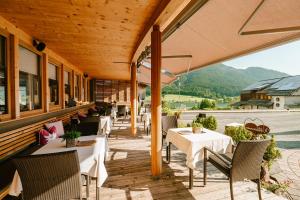 a restaurant with tables and chairs on a patio at Arlbergerhof Vital in Weissensee