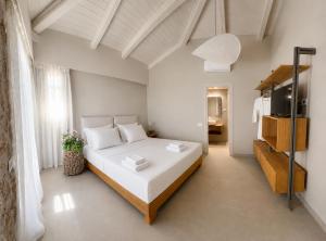 ein Schlafzimmer mit einem großen weißen Bett in einem Zimmer in der Unterkunft Villa Anthousa luxury villas and suites in Anthoúsa + 46 Fotos