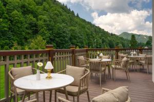 a patio with tables and chairs on a deck at Wanda Luxury Boutique Hotel - tylko dla dorosłych in Szczawnica