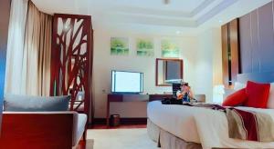 a woman sitting on a bed in a bedroom at Summer Hotel in Dong Quan