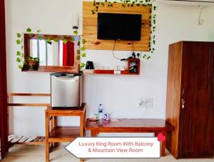 a living room with a television and a wooden table at Rock Face Palace in Ella