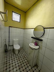 a bathroom with a toilet and a sink and a mirror at Triple A Kundasang in Ranau