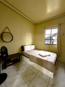 a bedroom with a bed with a mirror and a window at Triple A Kundasang in Ranau