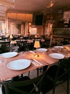 a table in a restaurant with white plates on it at Au bon clocher in Canari