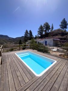 a swimming pool on a deck with a wooden floor at Montaña Las Tortolas in San Bartolomé