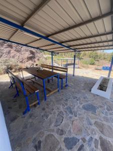 a picnic table and benches under a roof at Montaña Las Tortolas in San Bartolomé