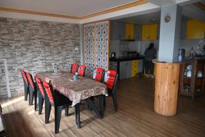 a dining room with a table and red chairs at Denzongpa Homestay in Takdāh