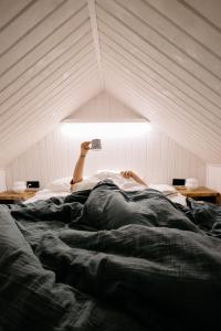 a person laying on top of a bed in a room at Okno na Beskidy -domek NIEBO z balią , sauną i niesamowitym widokiem na góry in Maków Podhalański