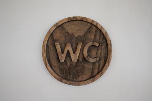 a wooden sign with the wordwcs on a wall at Jahta Engures ostā in Engure