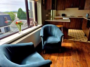 a living room with two chairs and a window at Cuchulainn Townhouse in Galway