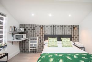 a bedroom with a large bed and a microwave at The Belmont Suits in Liverpool