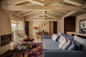 a living room with a blue couch and a fireplace at Petra Segreta Resort & Spa in San Pantaleo