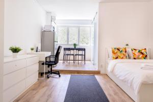 a bedroom with a bed and a desk and a kitchen at Deda Studio w. Smart TV · AC · washing machine in Bucharest