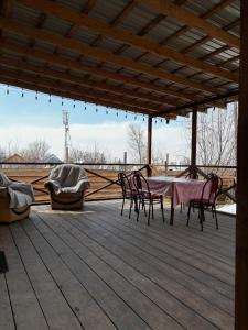 a patio with a table and chairs on a deck at Дом твоей силы in Talghar