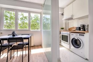 a kitchen with a dining table and a washing machine at Deda Studio w. Smart TV · AC · washing machine in Bucharest