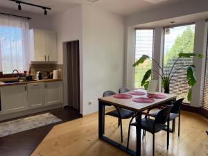 a kitchen and dining room with a table and chairs at Cozy Garden Apartment Near Krakow - Free Parking in Gaj