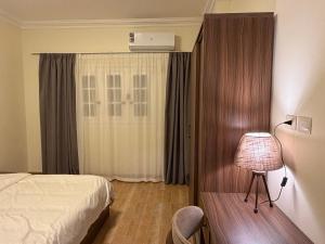 a bedroom with a bed and a lamp and a window at 瑞龙居民宿 in New cairo
