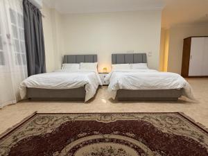 a bedroom with two beds and a rug at 瑞龙居民宿 in New cairo +17 photos