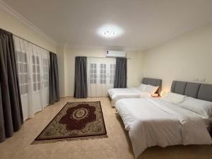 a bedroom with two beds and a rug at 瑞龙居民宿 in New cairo