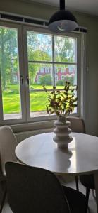 a white table with a plant in a vase on it at Glaskogen Holiday Homes in Glava